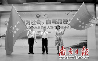 谭培安为学校授旗。