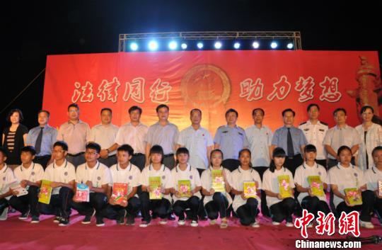 图为各界人士向中学生发放禁毒书籍　林浩　摄