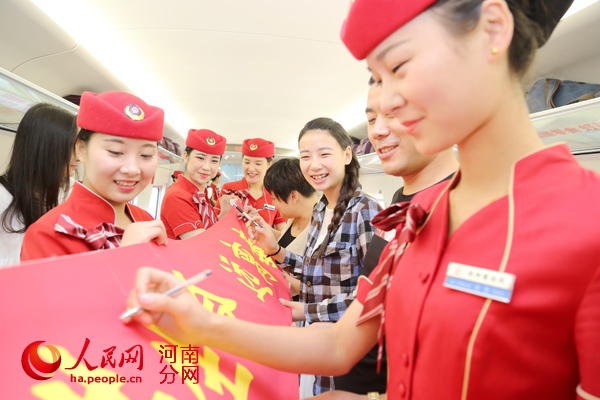 高铁姑娘和旅客们在&ldquo;珍惜生命、远离毒品&rdquo;条幅上签名