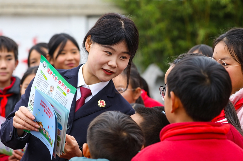 2025年12月24日，黔西市检察院检察干警到绿化白族彝族乡培育小学开展法治安全宣传教育活动。图为检察干警正在给学生们讲解《健康人生 绿色无毒》禁毒宣传资料中相关法律法规。。.jpg